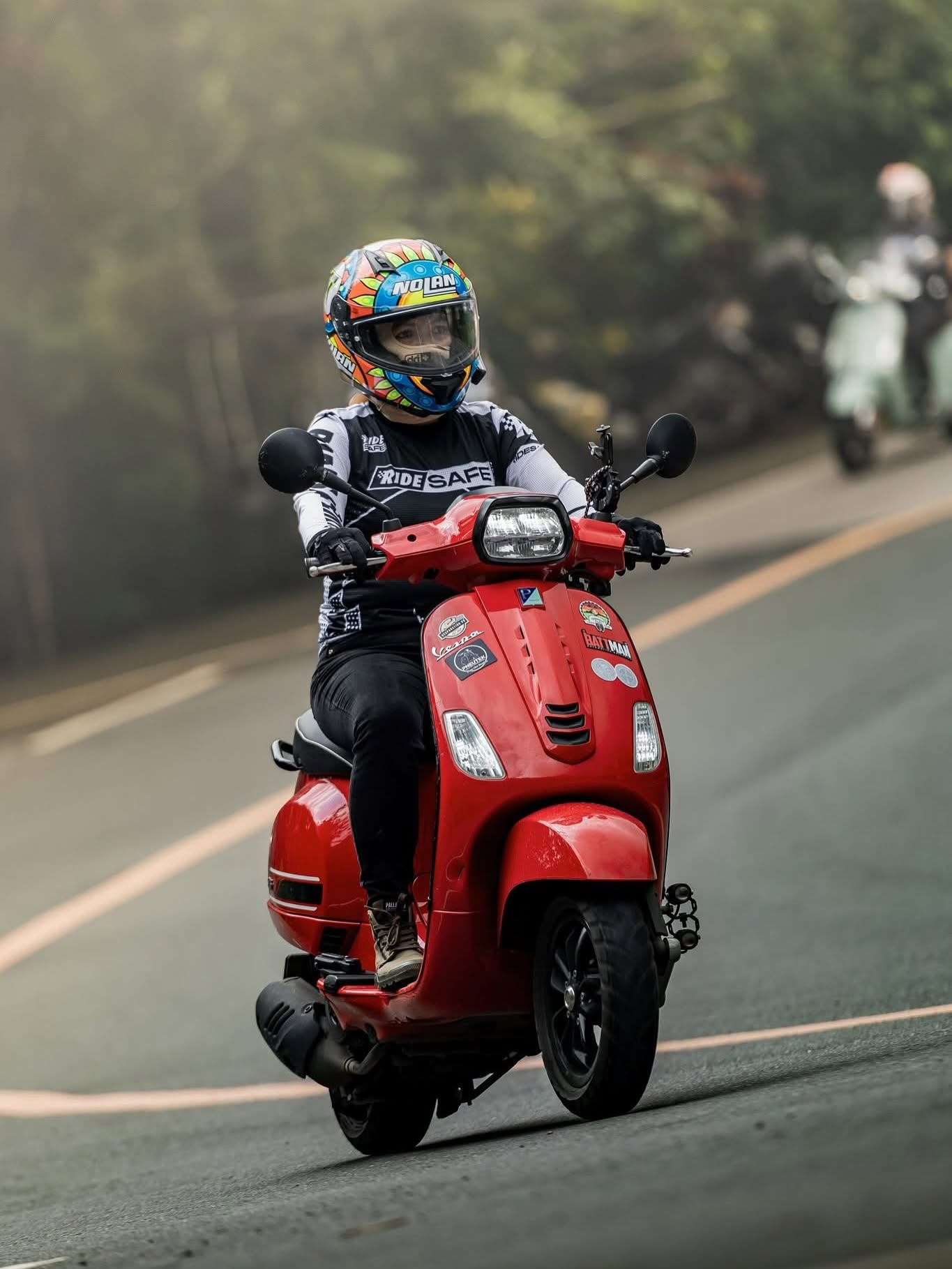 Complete photo of a Ride Safe rider on a red scooter